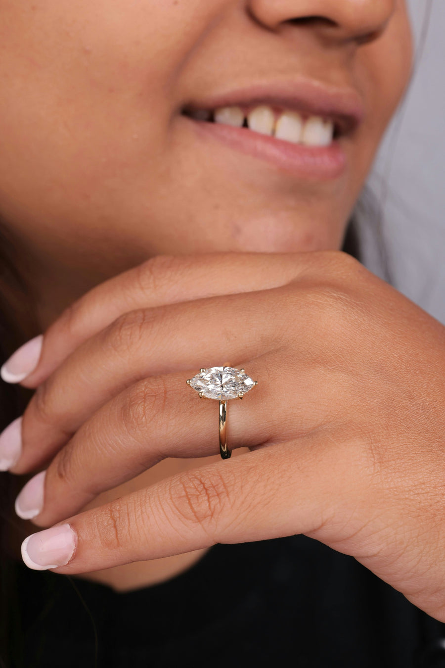 A marquise cut diamond solitaire in yellow gold, worn on the hand