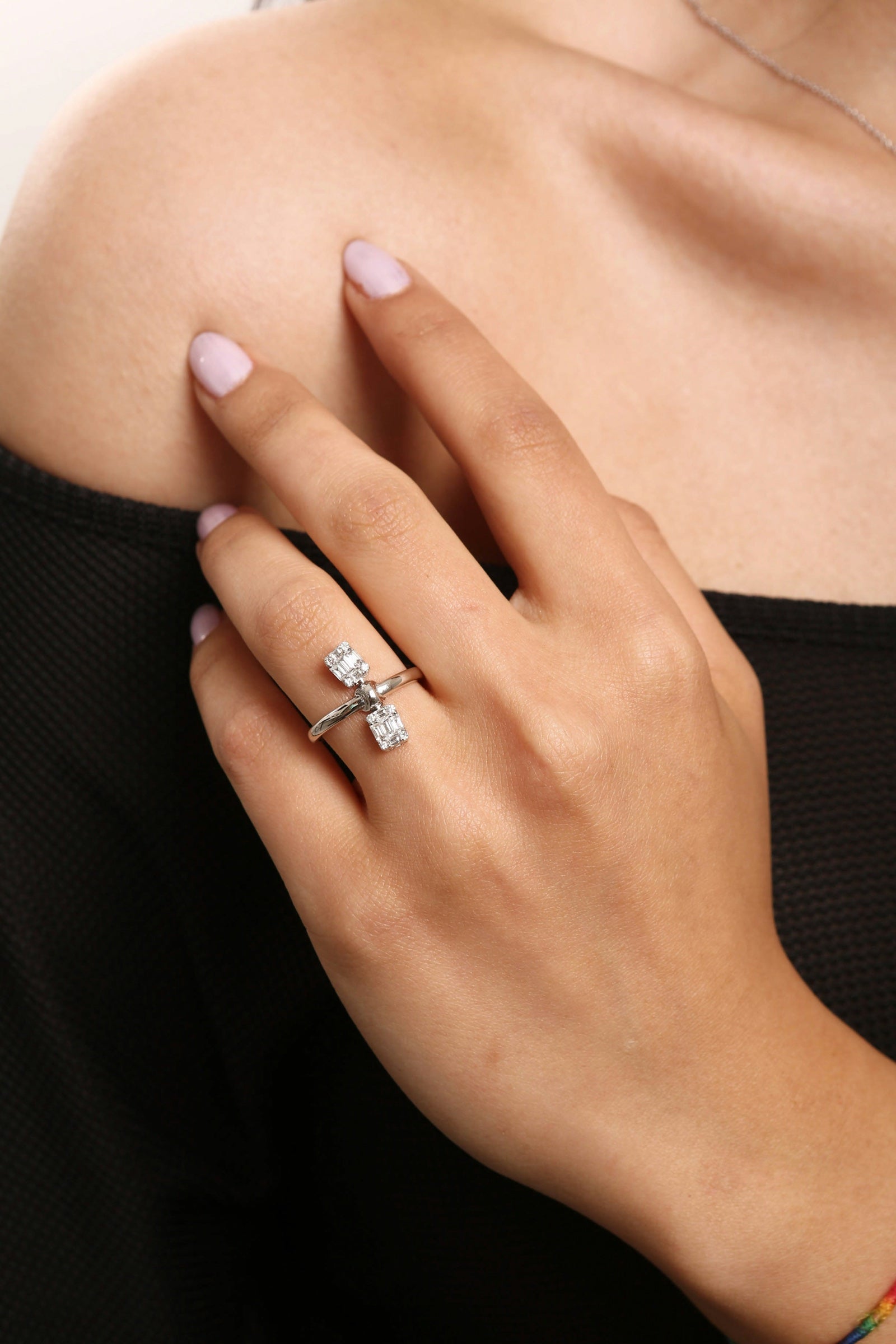 A two stone diamond ring in white gold, worn on the hand